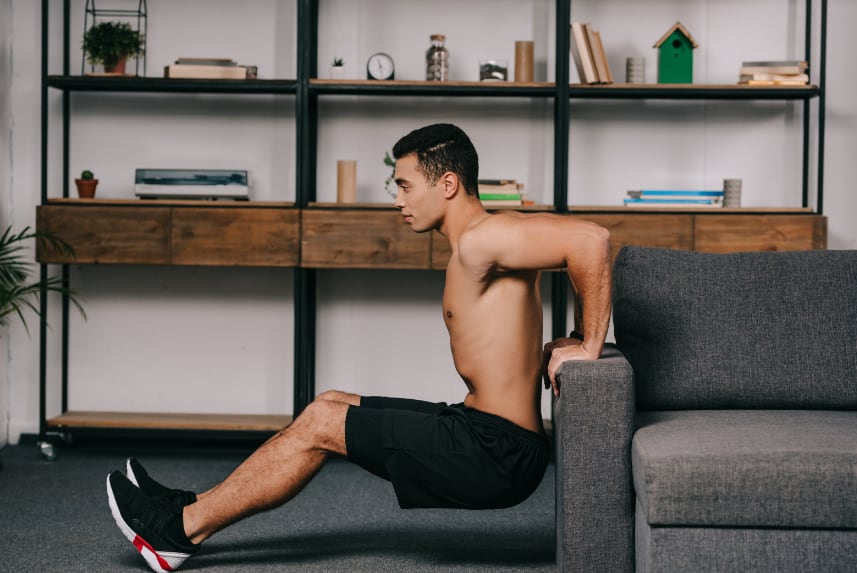  Man doing crunches on the arm of a sofa.